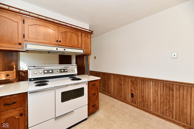 kitchen featuring white range with electric cooktop and wood walls