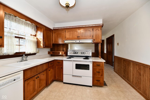 kitchen with wood walls, white appliances, and sink