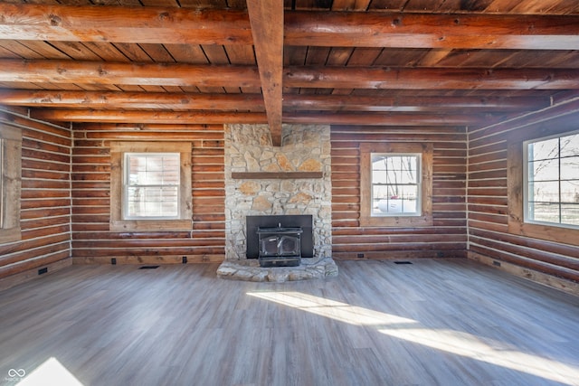 unfurnished living room with wood-type flooring, a wood stove, wooden ceiling, and beam ceiling