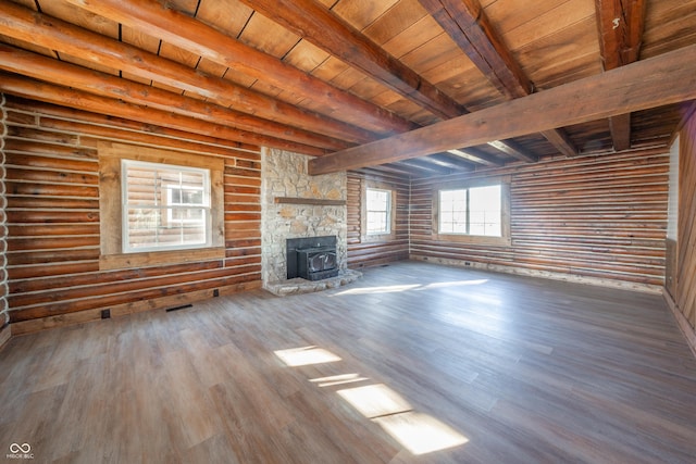 unfurnished living room with hardwood / wood-style floors, vaulted ceiling with beams, a wood stove, and wood ceiling