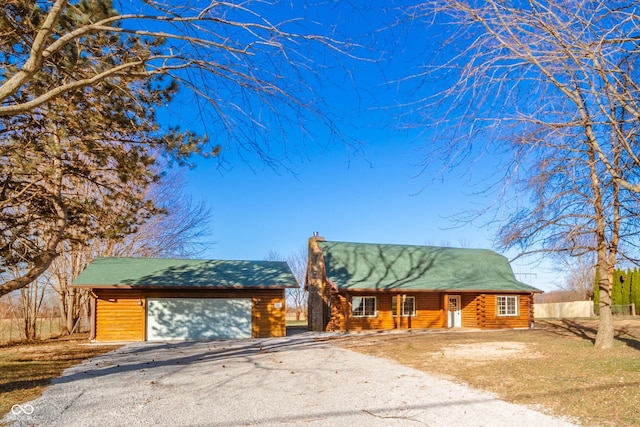 log-style house with a garage and an outdoor structure