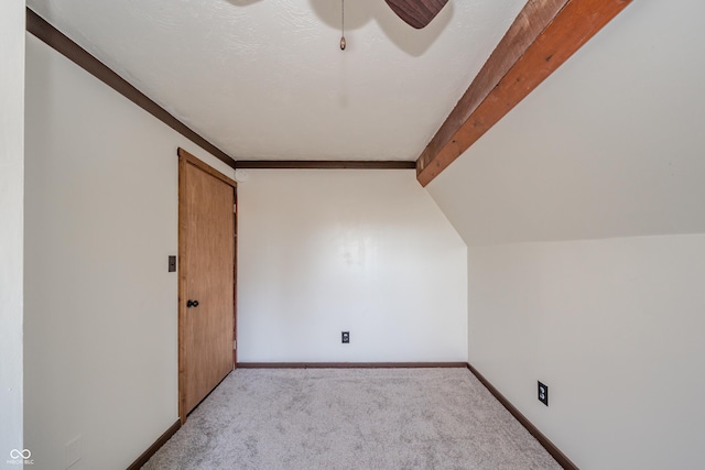 additional living space with vaulted ceiling with beams, ceiling fan, and light colored carpet