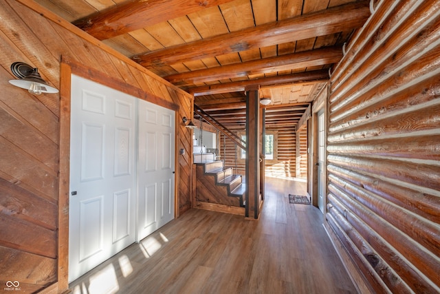 entryway with beam ceiling, hardwood / wood-style floors, log walls, and wooden ceiling