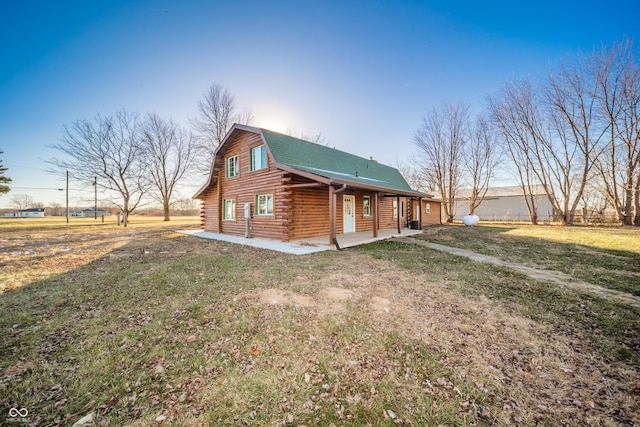 view of side of property featuring a lawn and a patio area