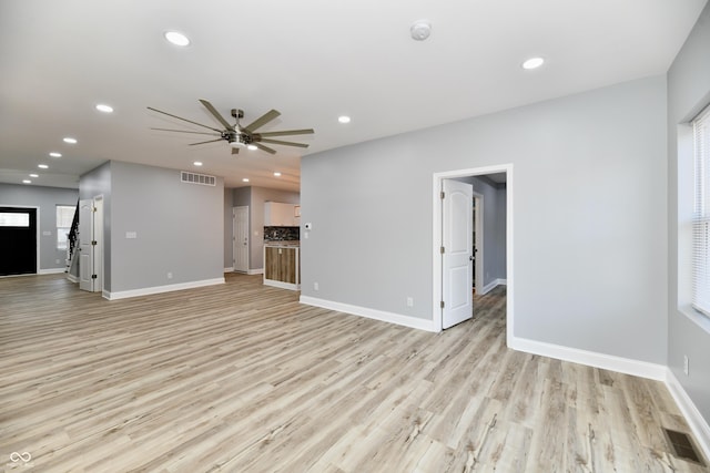 unfurnished living room featuring ceiling fan and light hardwood / wood-style flooring