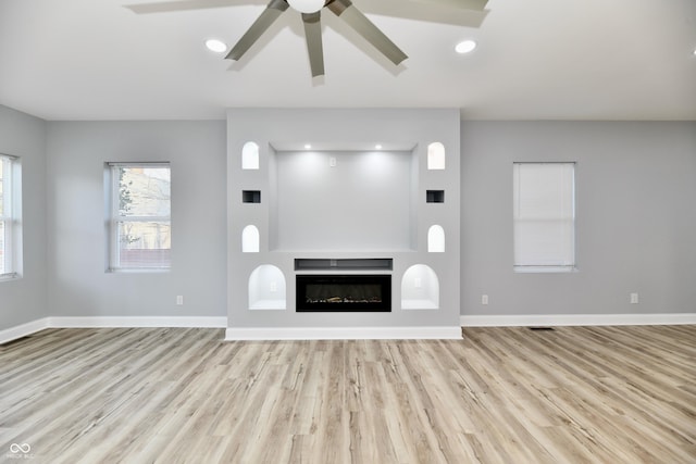 unfurnished living room with ceiling fan and light hardwood / wood-style floors