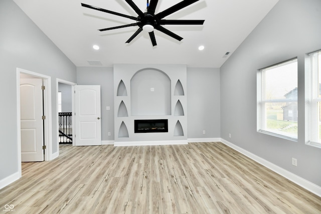 unfurnished living room with light hardwood / wood-style floors, ceiling fan, and lofted ceiling