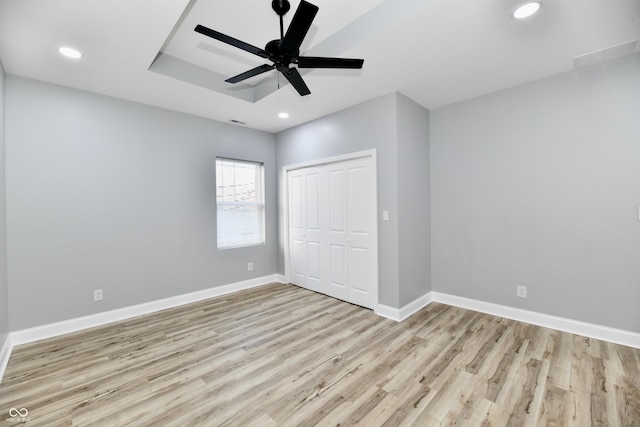 unfurnished bedroom featuring a closet, light hardwood / wood-style floors, and ceiling fan