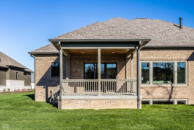 rear view of house with a porch and a yard