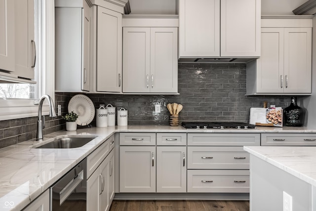 kitchen with dishwasher, backsplash, sink, gas stovetop, and light stone counters