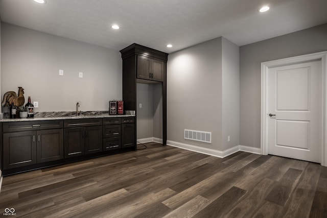 kitchen with dark brown cabinets, dark wood-type flooring, and sink