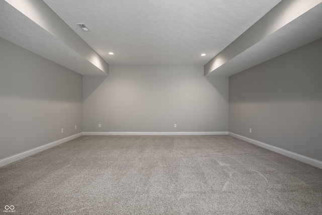 additional living space featuring carpet flooring and a textured ceiling