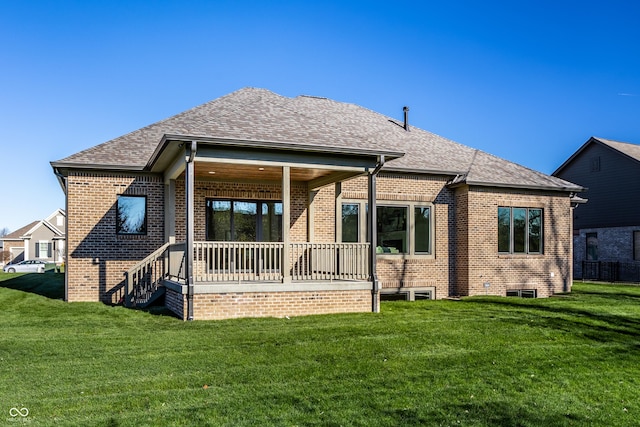 rear view of property featuring a lawn