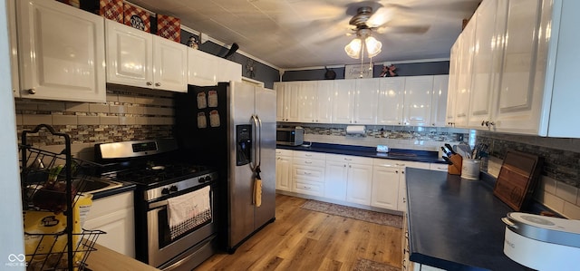 kitchen featuring appliances with stainless steel finishes, white cabinetry, tasteful backsplash, ornamental molding, and light hardwood / wood-style floors