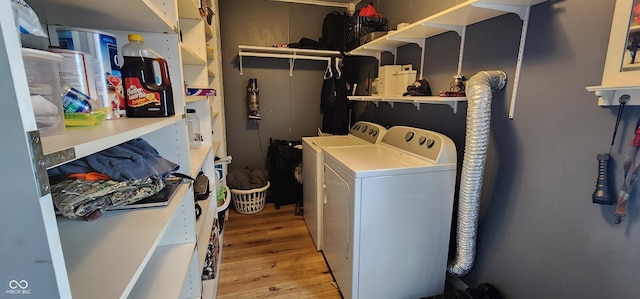 washroom featuring washing machine and dryer and light hardwood / wood-style flooring