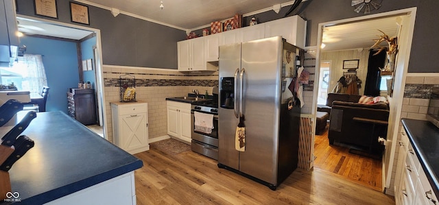 kitchen with sink, crown molding, light hardwood / wood-style flooring, stainless steel appliances, and white cabinets