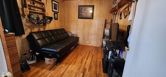 living room with hardwood / wood-style flooring and wooden walls