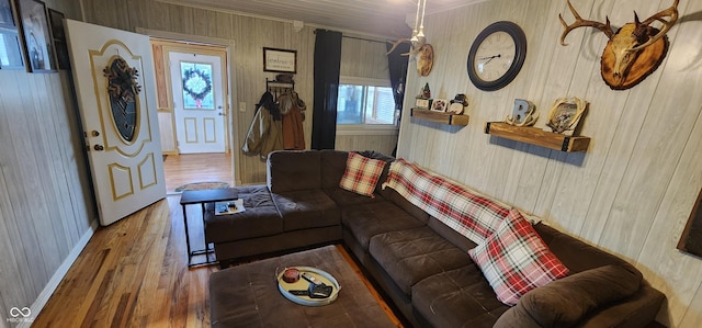 living room with crown molding, plenty of natural light, hardwood / wood-style floors, and wooden walls