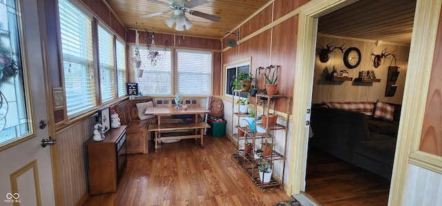 interior space featuring ceiling fan, wood walls, hardwood / wood-style floors, and wooden ceiling