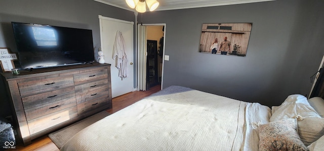 bedroom with wood-type flooring and ornamental molding