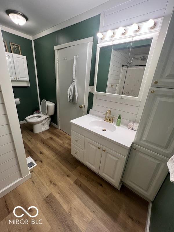 bathroom featuring vanity, hardwood / wood-style floors, and toilet