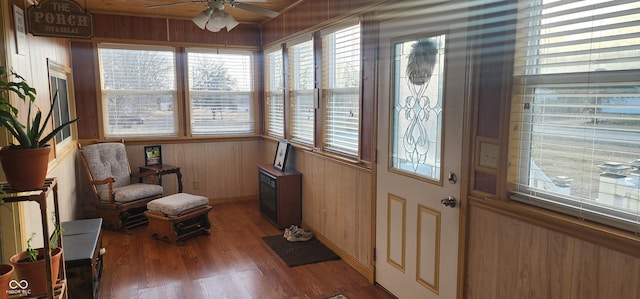 entryway featuring hardwood / wood-style floors, wooden walls, and ceiling fan