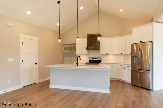 kitchen featuring a center island with sink, decorative light fixtures, white cabinetry, and stainless steel appliances