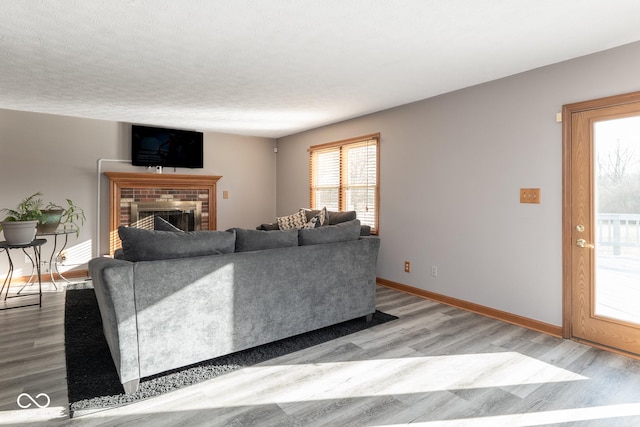 living room featuring a fireplace, light hardwood / wood-style floors, and a textured ceiling