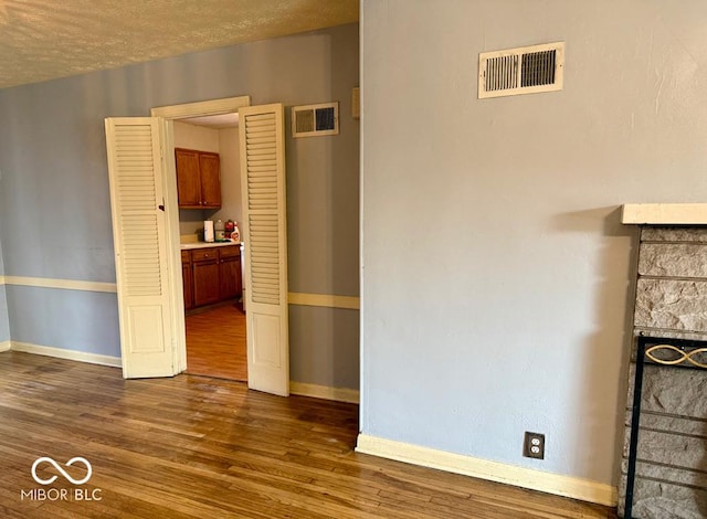 interior space with a textured ceiling and dark wood-type flooring