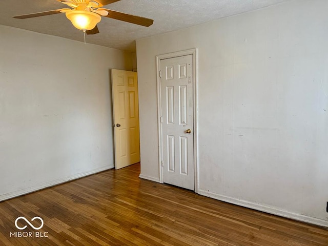 unfurnished room featuring hardwood / wood-style floors, ceiling fan, and a textured ceiling