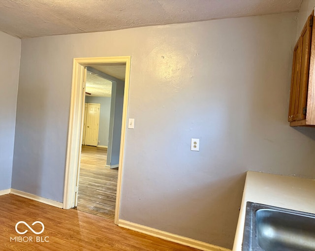 unfurnished dining area featuring hardwood / wood-style flooring, sink, and a textured ceiling