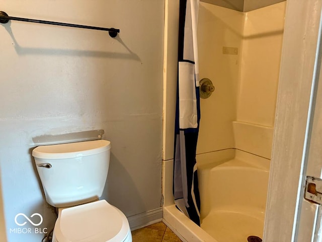 bathroom featuring tile patterned floors, toilet, and walk in shower