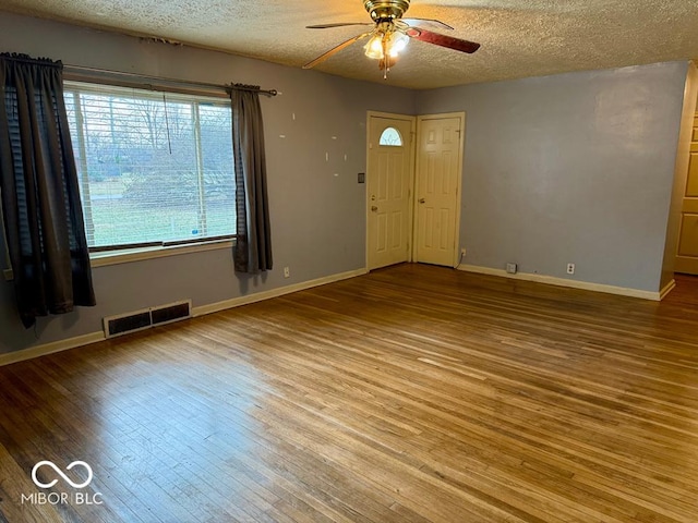 unfurnished room featuring hardwood / wood-style floors, ceiling fan, and a textured ceiling