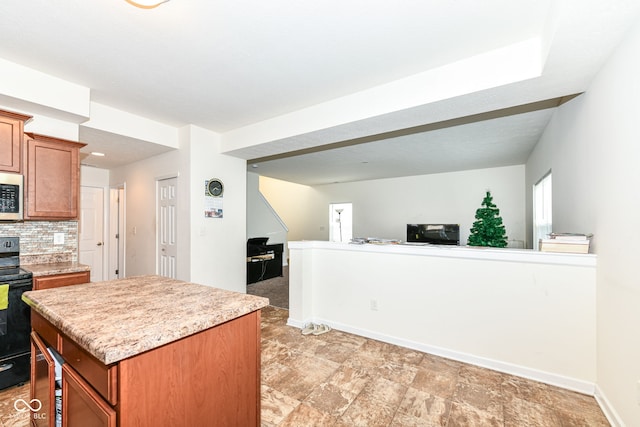 kitchen featuring tasteful backsplash, a center island, and electric range