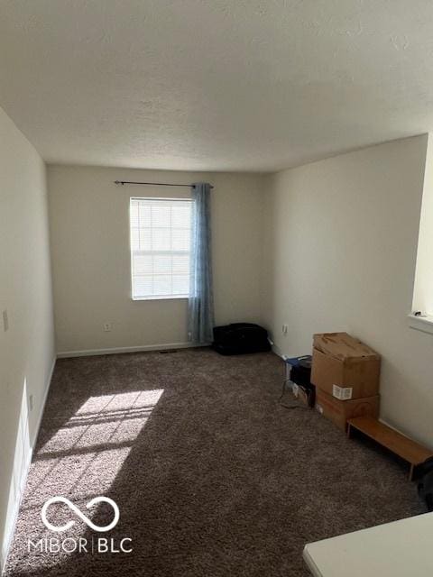 unfurnished room with dark carpet