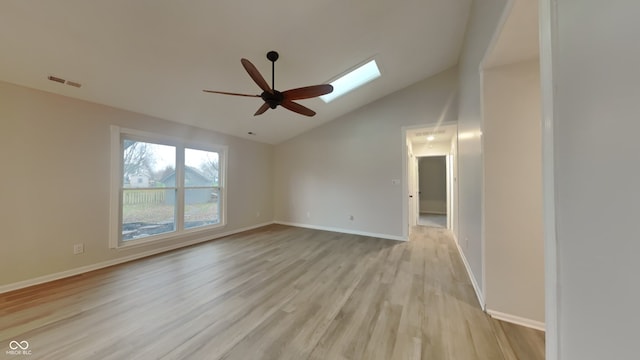 unfurnished room featuring a skylight, ceiling fan, light hardwood / wood-style flooring, and high vaulted ceiling