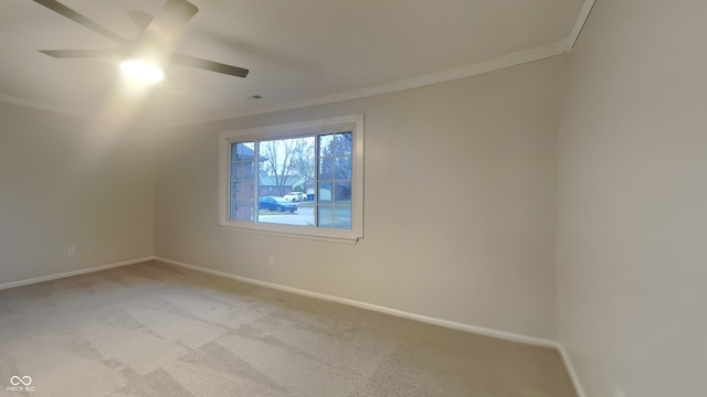 carpeted spare room featuring ceiling fan and crown molding