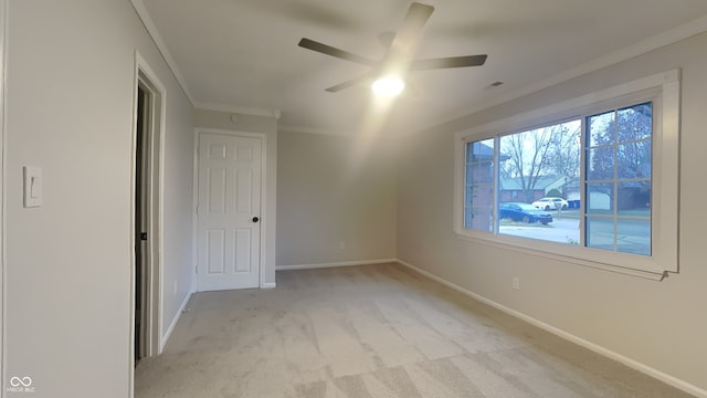 unfurnished bedroom featuring ceiling fan, light colored carpet, and ornamental molding