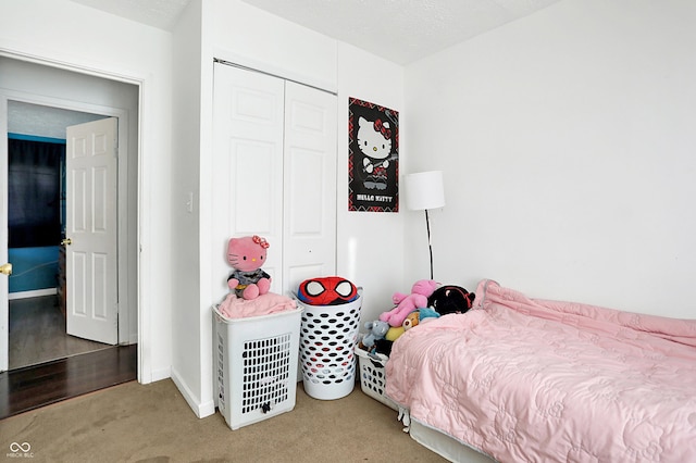 bedroom with carpet flooring, a textured ceiling, and a closet