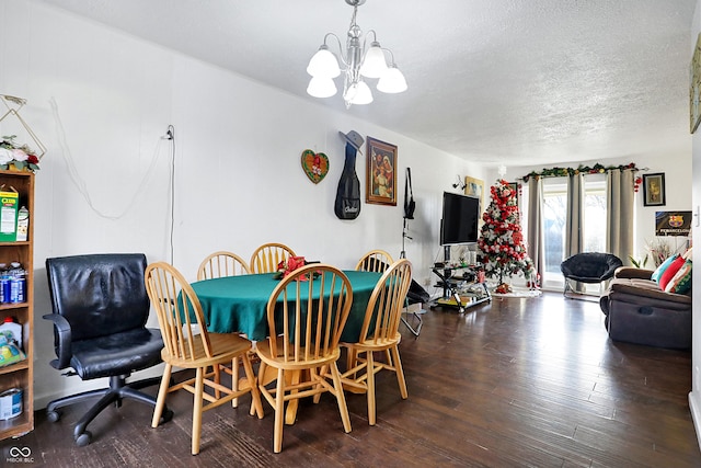 dining space featuring wood-type flooring, a textured ceiling, and a notable chandelier