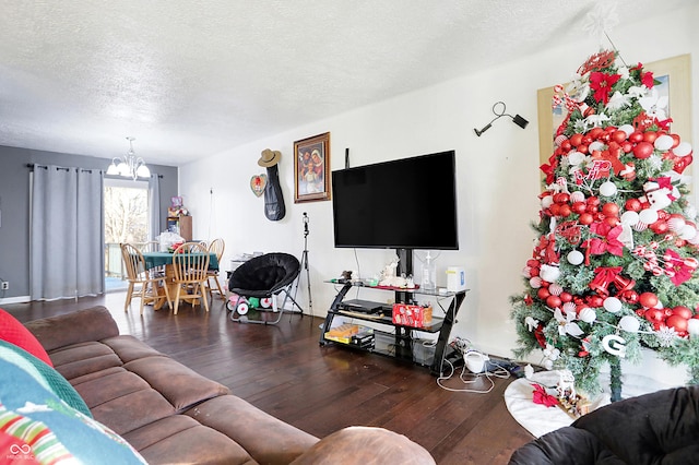 living room featuring hardwood / wood-style floors, a textured ceiling, and an inviting chandelier