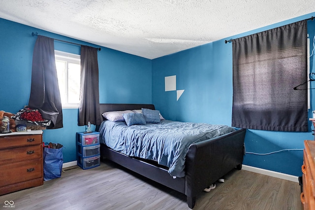 bedroom featuring light wood-type flooring and a textured ceiling