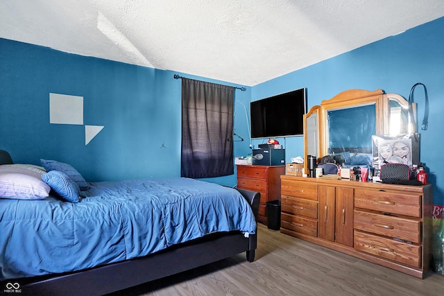 bedroom featuring a textured ceiling and hardwood / wood-style flooring