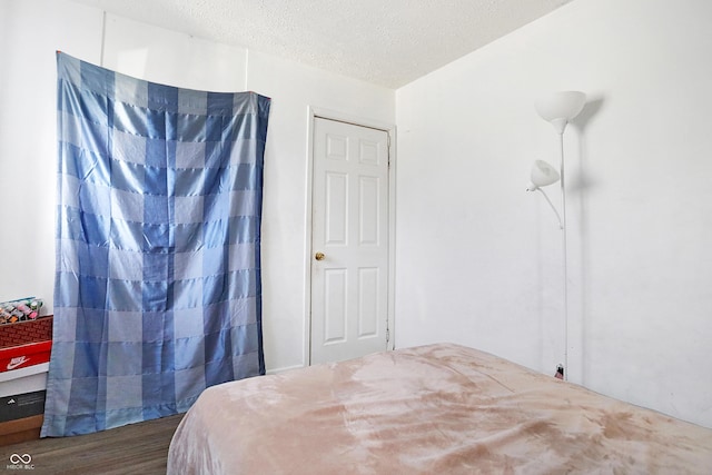 bedroom featuring dark hardwood / wood-style flooring and a textured ceiling