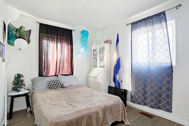 bedroom with wood-type flooring and a textured ceiling