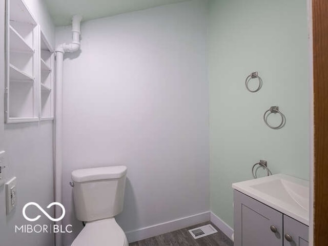 bathroom with vanity, wood-type flooring, and toilet