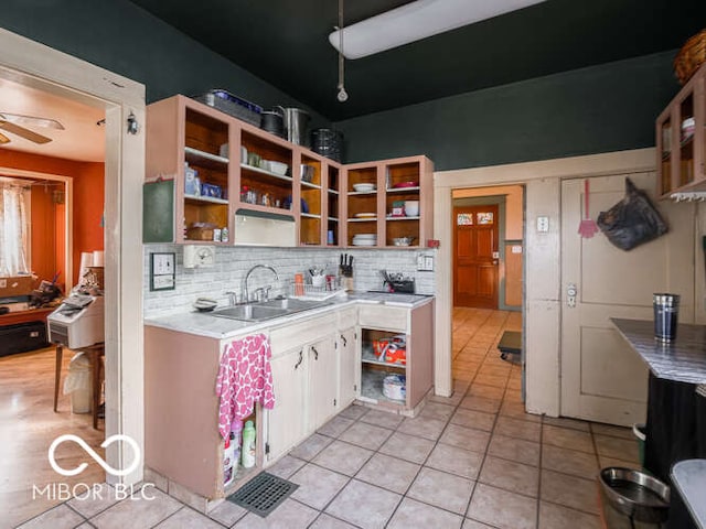 kitchen with backsplash, ceiling fan, sink, light tile patterned floors, and white cabinets