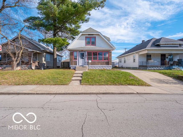 bungalow with covered porch and a front yard