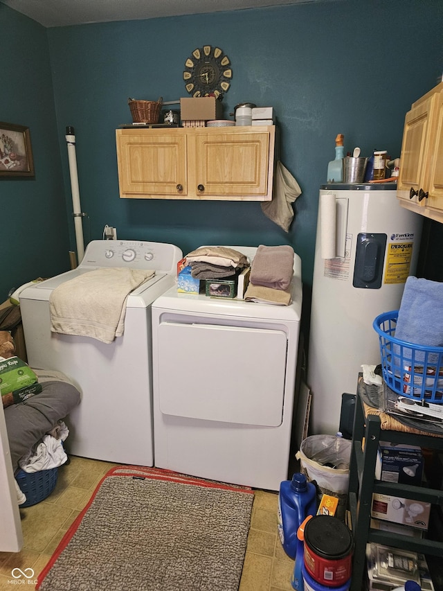 laundry room with cabinets, electric water heater, and washing machine and clothes dryer