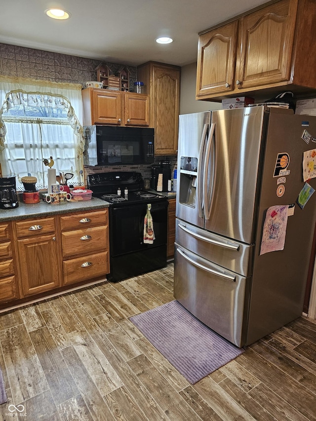 kitchen featuring decorative backsplash, black appliances, and dark hardwood / wood-style floors